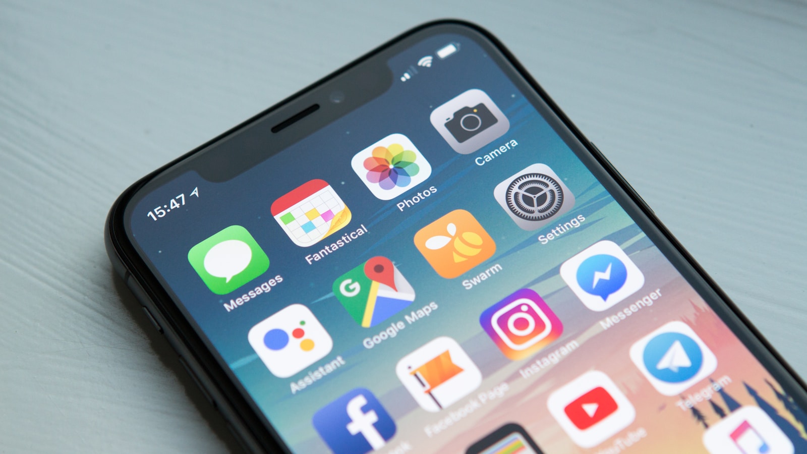 Smartphone com aplicativos, representando apps de questões para concursos públicos