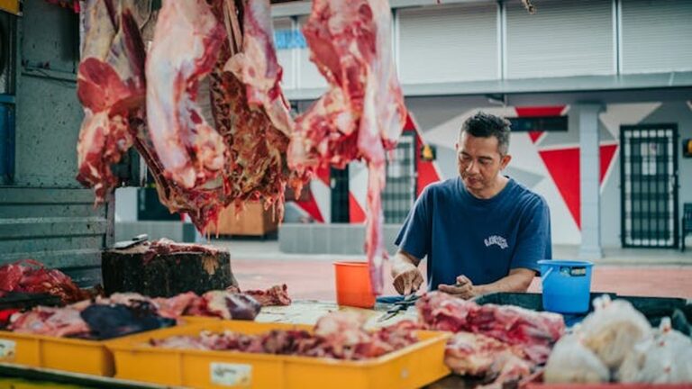 Açougueiro trabalhando em balcão de carnes.