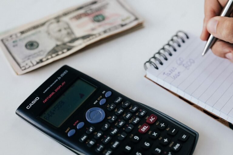 Pessoa organizando orçamento pessoal com calculadora, representando curso gratuito de educação financeira da Fundação Bradesco