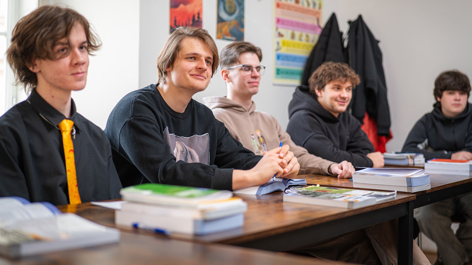 Estudantes em sala de aula com livros, representando curso gratuito de espanhol para iniciantes