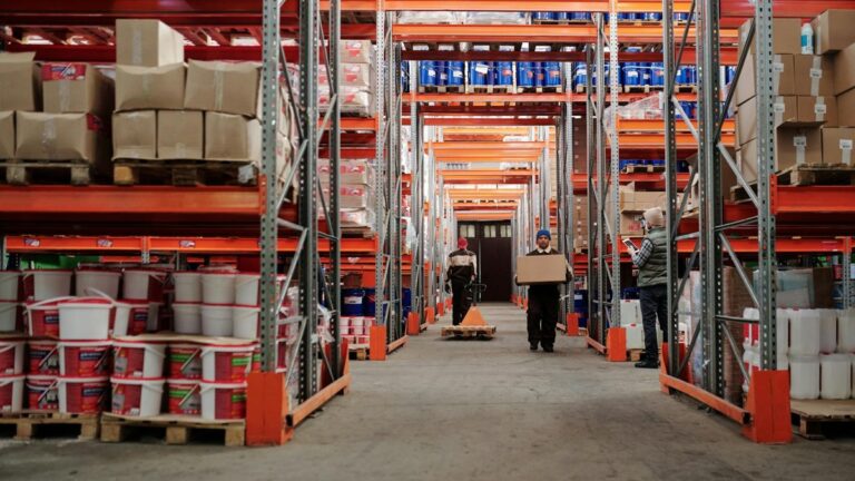 Trabalhadores organizando caixas em estoque de armazém