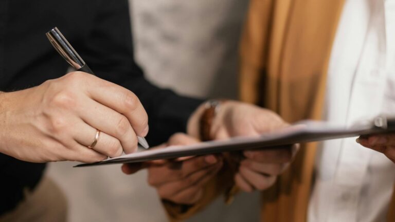 Profissionais assinando documento de negociação ou contrato