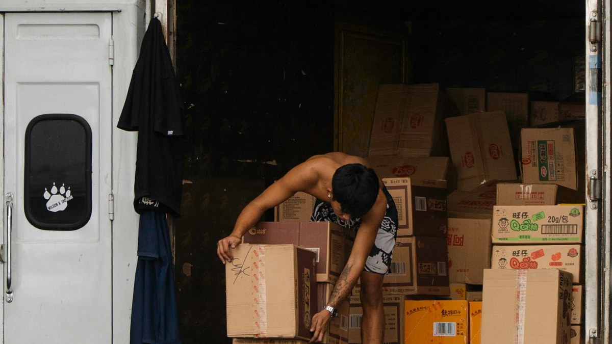 Trabalhador organizando caixas em operação de entrega e logística