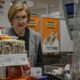 Operadora de caixa atendendo cliente em supermercado