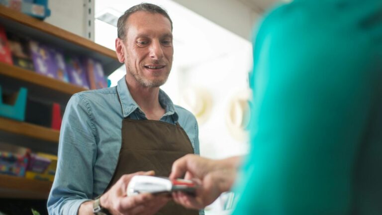 Vendedor atendendo cliente em loja no momento da compra