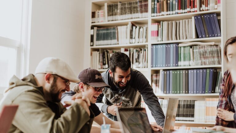 Estudantes em ambiente universitário usando notebook, representando curso de inglês avançado online