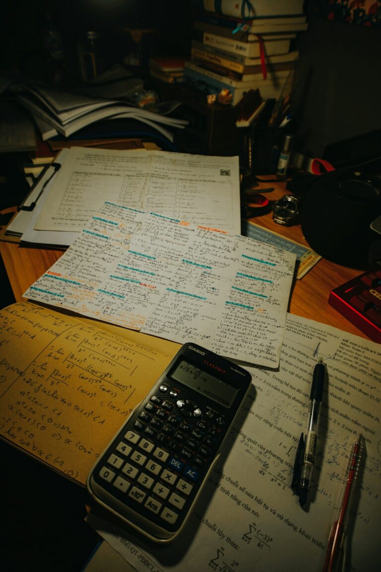 Mesa de estudos com calculadora, canetas e papéis para preparação de Matemática do ENEM