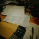 Mesa de estudos com calculadora, canetas e papéis para preparação de Matemática do ENEM
