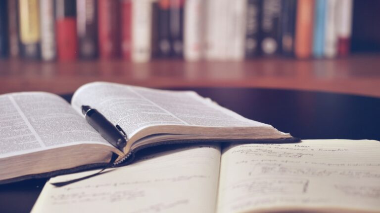Livro aberto e caderno de estudos para preparação de Português em concursos públicos