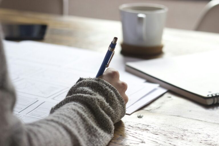 Pessoa escrevendo em papel de prova durante estudo para concursos públicos