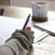 Pessoa escrevendo em papel de prova durante estudo para concursos públicos