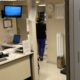 Área de recepção médica com balcão de atendimento em ambiente de saúde.