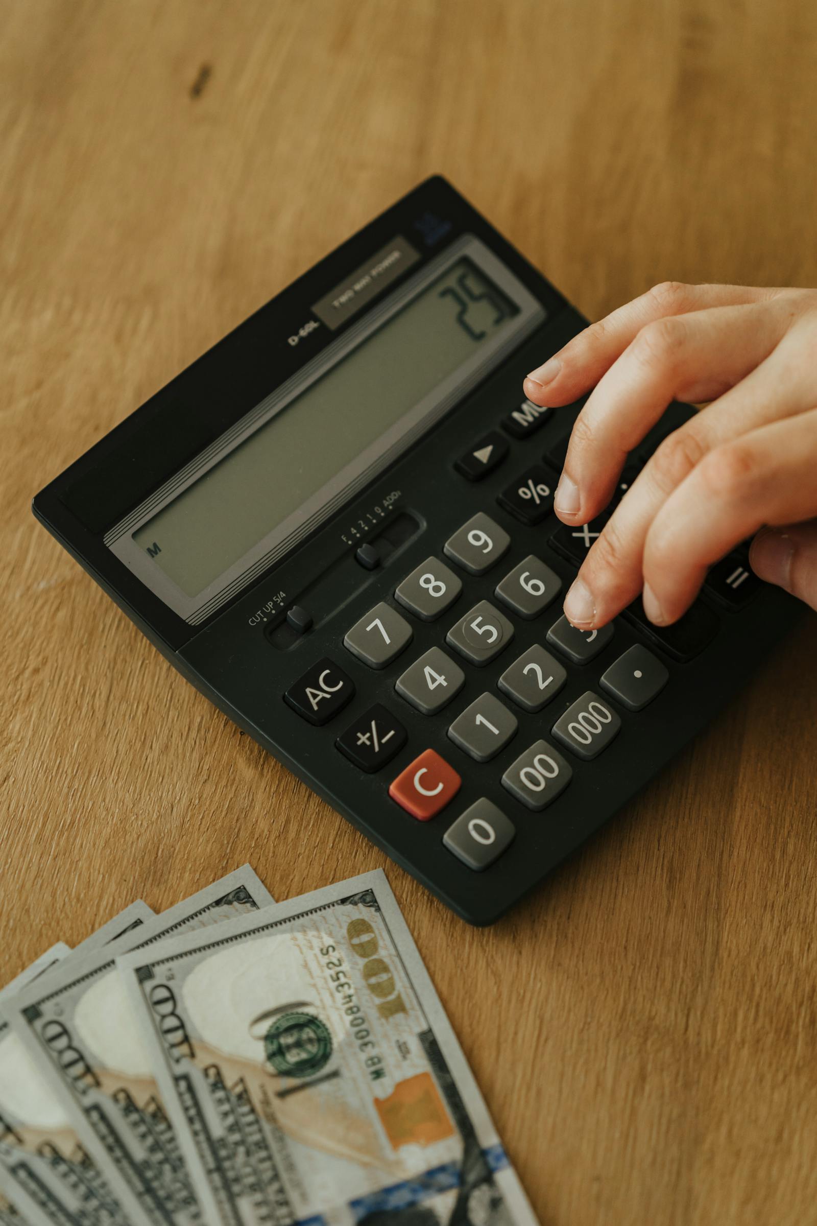 Pessoa usando calculadora para controlar gastos e despesas pessoais