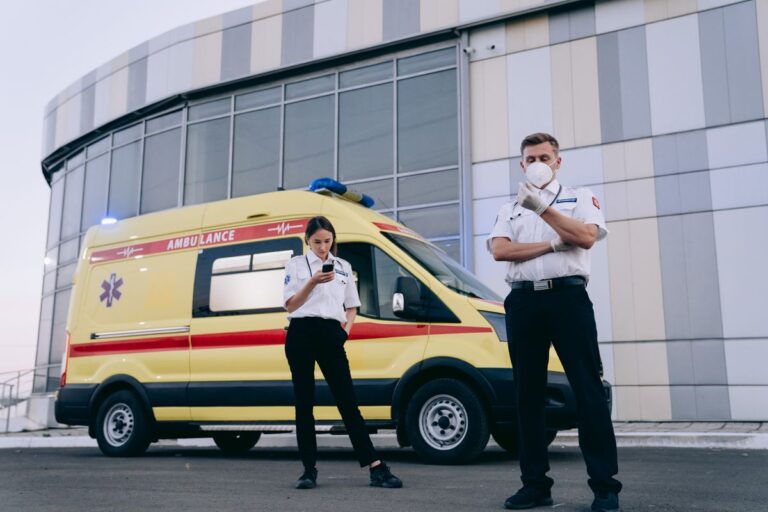 Profissionais próximos a ambulância, representando curso de condutor de veículos de emergência.