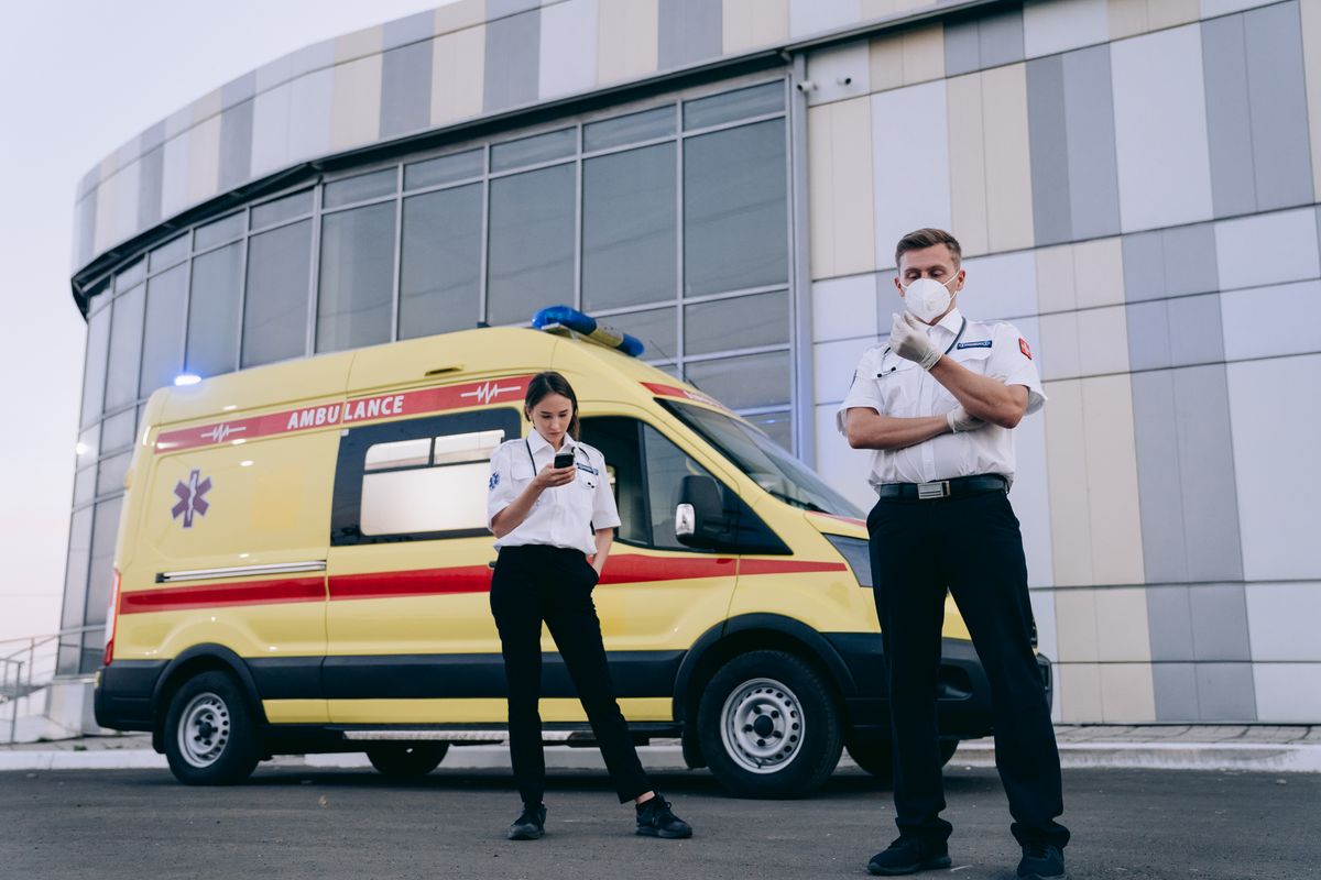 Profissionais próximos a ambulância, representando curso de condutor de veículos de emergência.