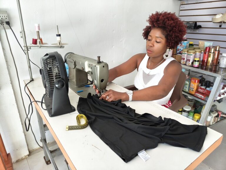 Profissional usando máquina de costura, representando curso de costureira de máquinas industriais.