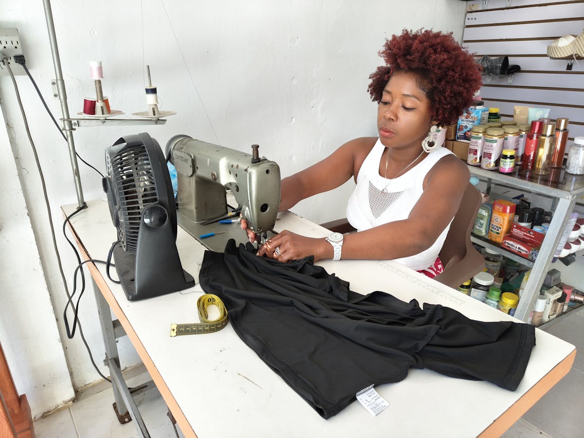 Profissional usando máquina de costura, representando curso de costureira de máquinas industriais.