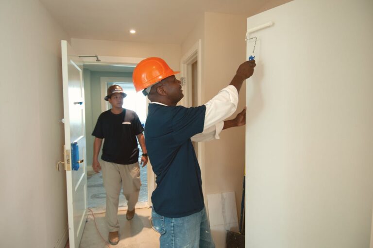 Trabalhadores pintando parede em obra, representando curso de pintor de obras.