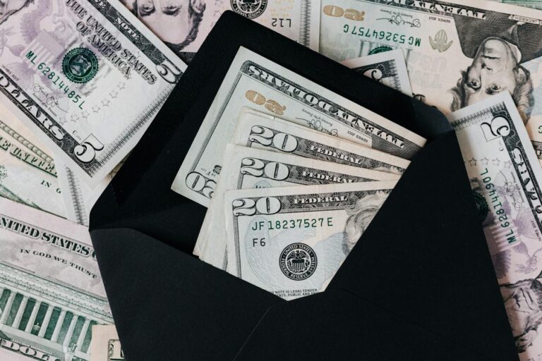 Pessoa organizando contas e planejamento financeiro em uma mesa.