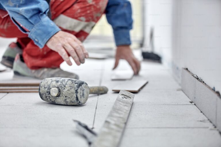 Profissional instalando piso e revestimento em obra