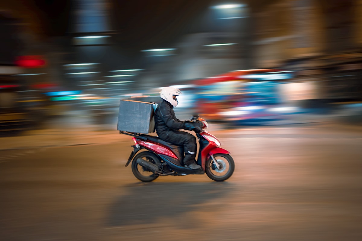 Entregador profissional conduzindo motocicleta com caixa de entrega