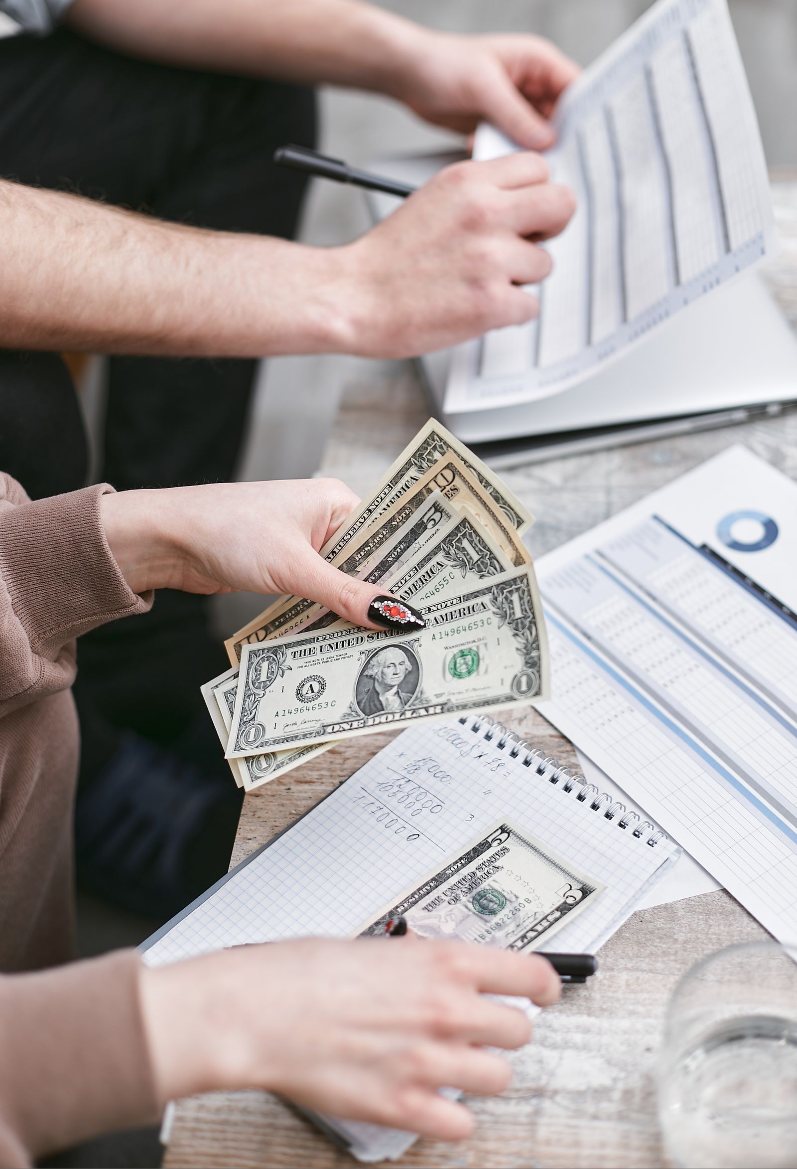Pessoas contando dinheiro e revisando documentos de educação financeira