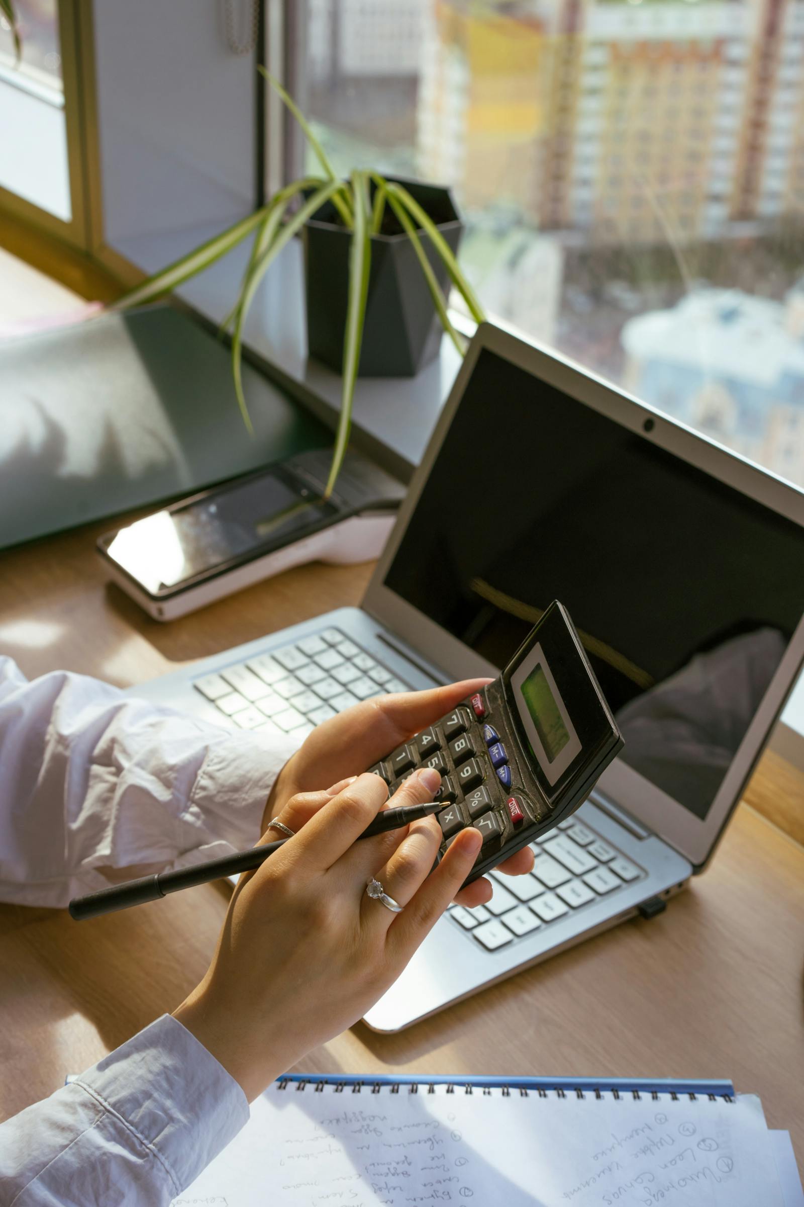 Pessoa usando laptop e calculadora para planejamento financeiro pessoal