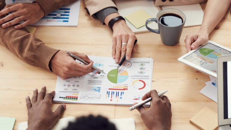Grupo analisando gráficos e planejamento, representando graduação EAD em administração pública.