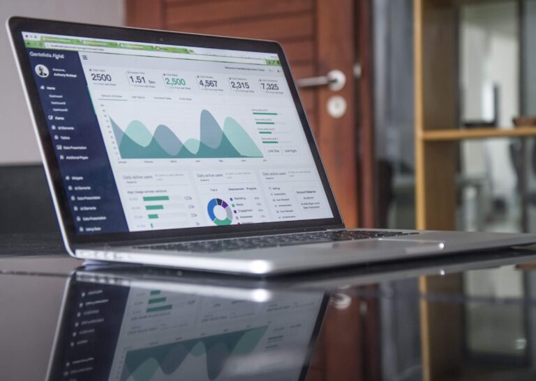 Notebook com gráficos e painel de dados representando curso gratuito de Excel