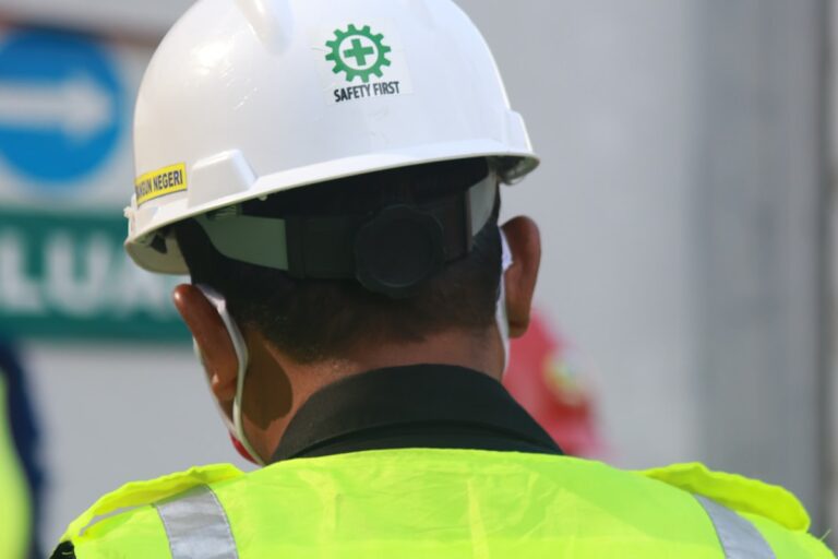 Trabalhador usando capacete e colete de segurança em ambiente ocupacional