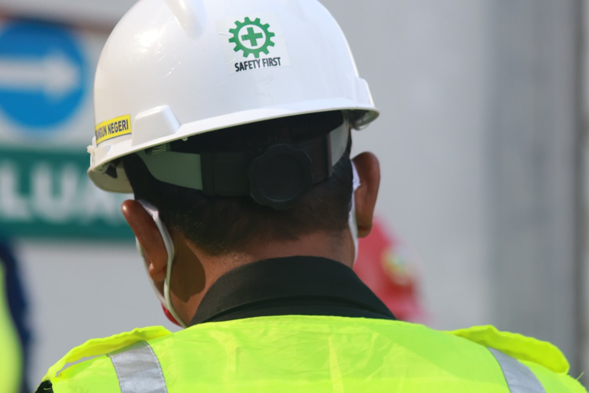 Trabalhador usando capacete e colete de segurança em ambiente ocupacional