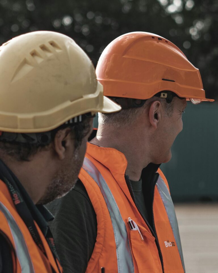 Trabalhadores usando capacete, colete e equipamentos de proteção em ambiente de trabalho