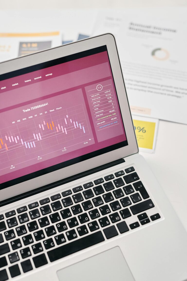Notebook com gráficos financeiros e documentos para estudo de investimentos